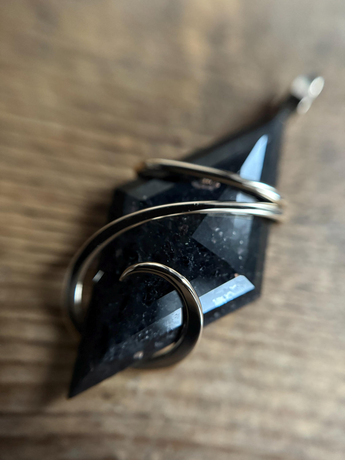 Faceted nuummite in 14k gold pendant