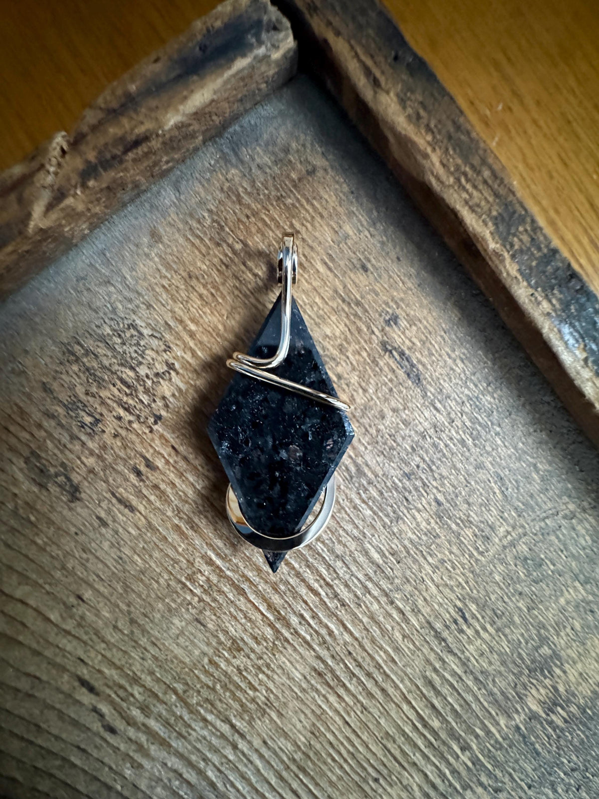 Faceted nuummite in 14k gold pendant
