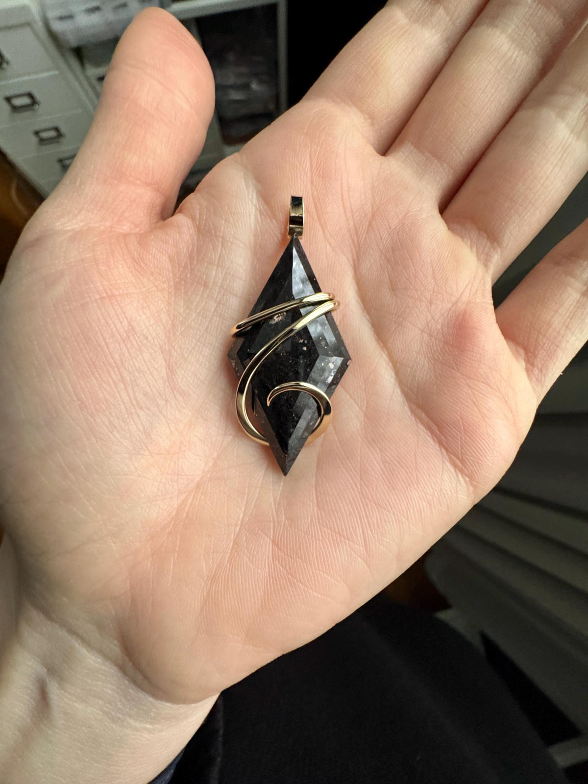 Faceted nuummite in 14k gold pendant