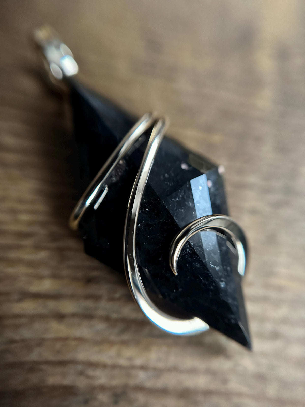 Faceted nuummite in 14k gold pendant